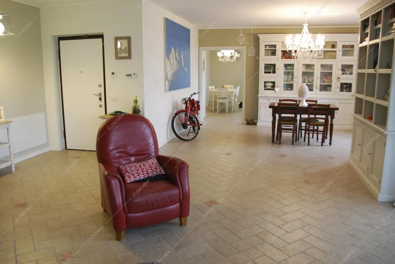 Poltrona, tavolo da pranzo e scorcio su un'altra zona pranzo 