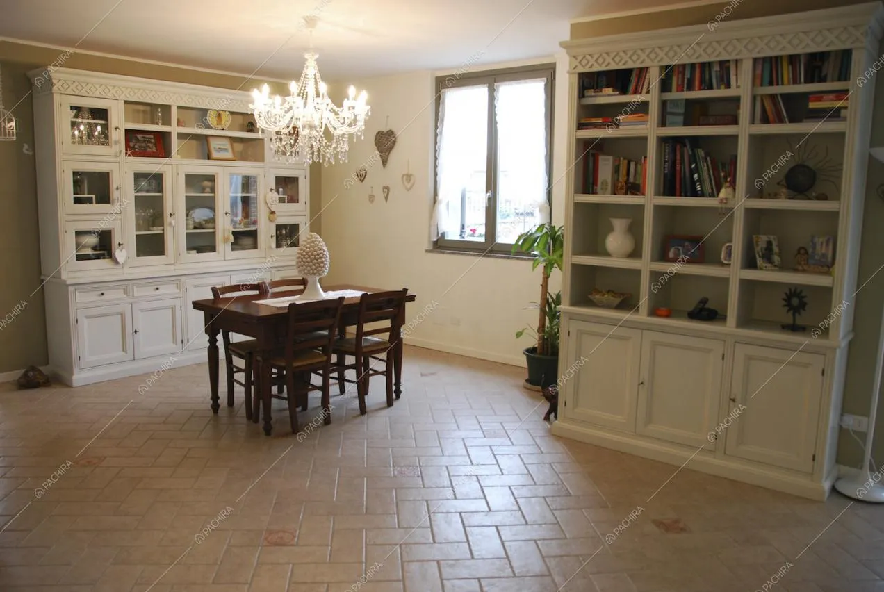 Librerie bianche a parete e lampadario in murano