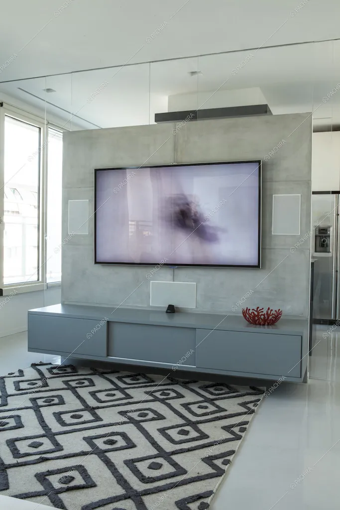 Televisione su parete in cemento lisciato, mobile sospeso