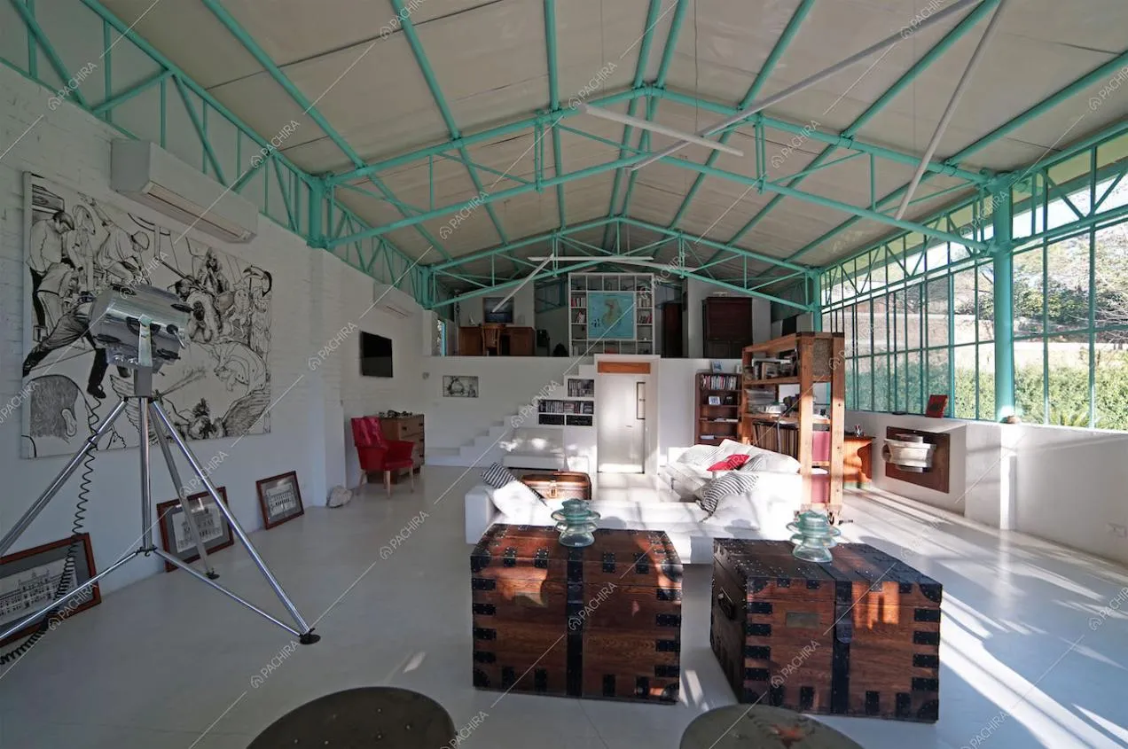 Zona living con divani bianchi, pavimento in cemento lisciato