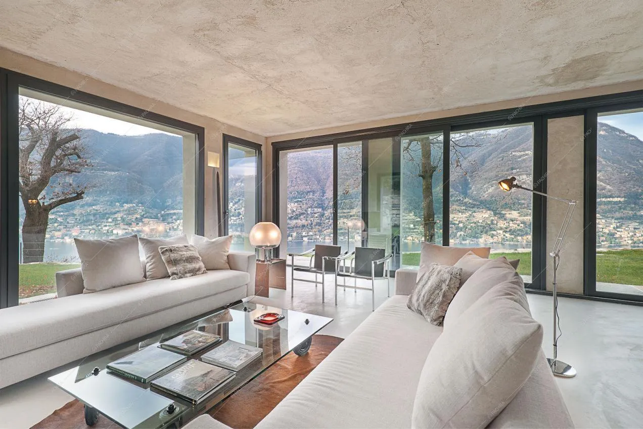 Zona living con divani bianchi e vetrate