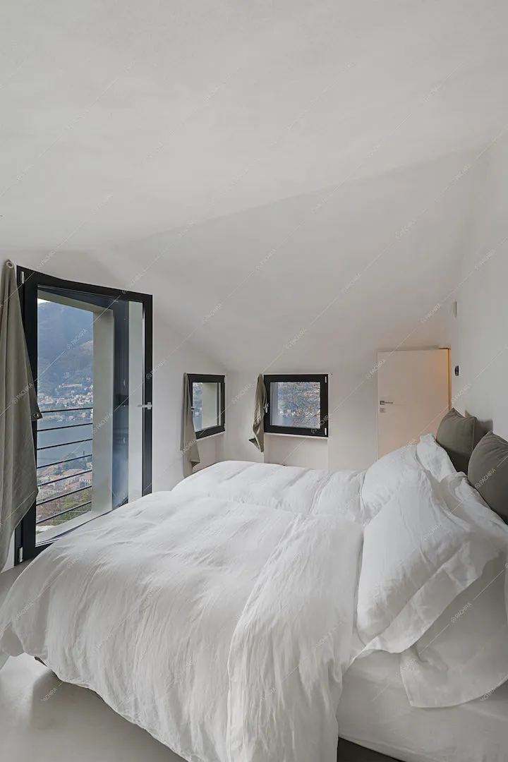 Camera da letto con vetrate vista lago