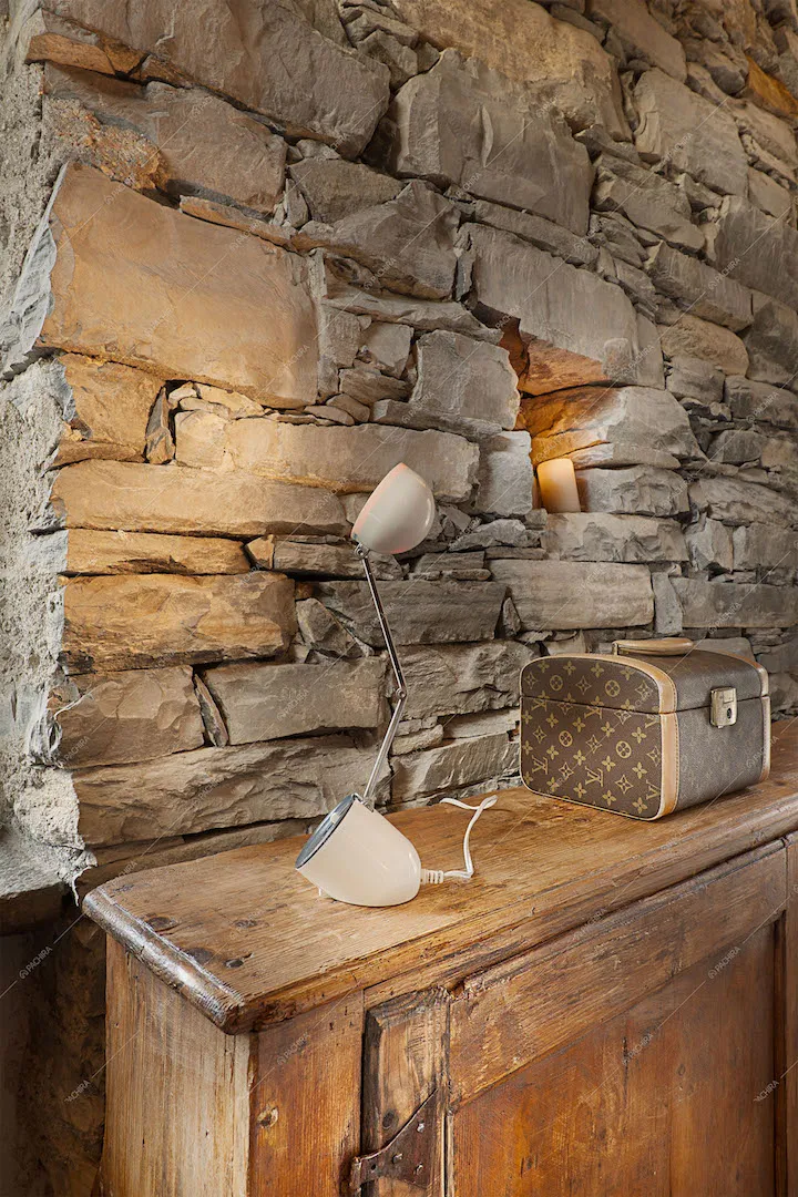 Mobile in legno grezzo e parete in pietra