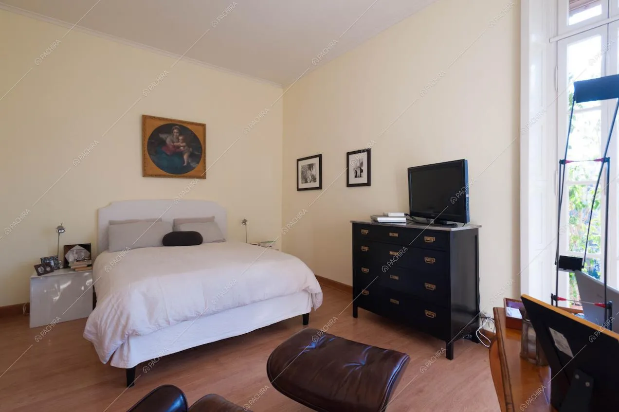 Camera da letto con pareti color panna e pavimento in parquet