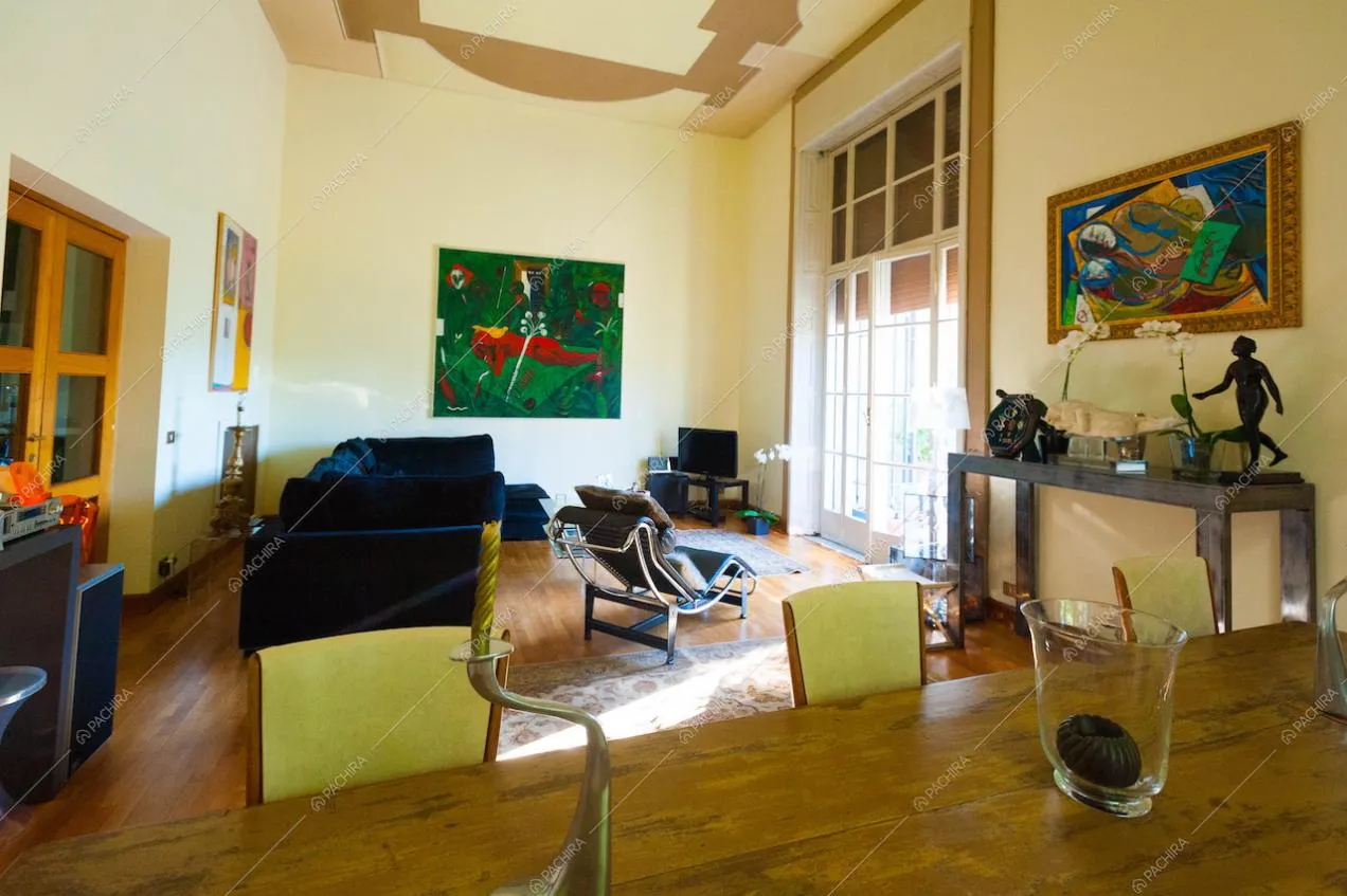 Il grande soggiorno con pareti beige e arredi di design
