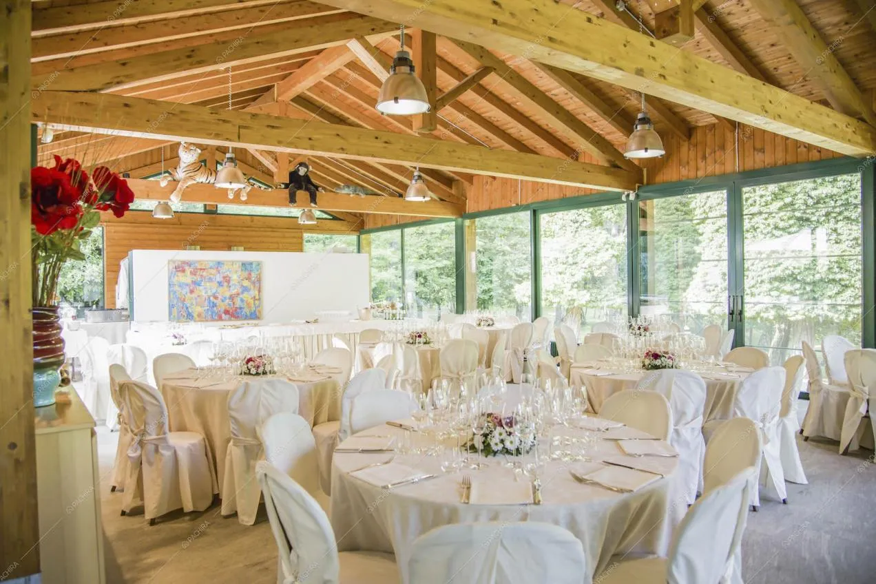 Salone da ricevimento con soffitto in travi in legno a vista e vetrate