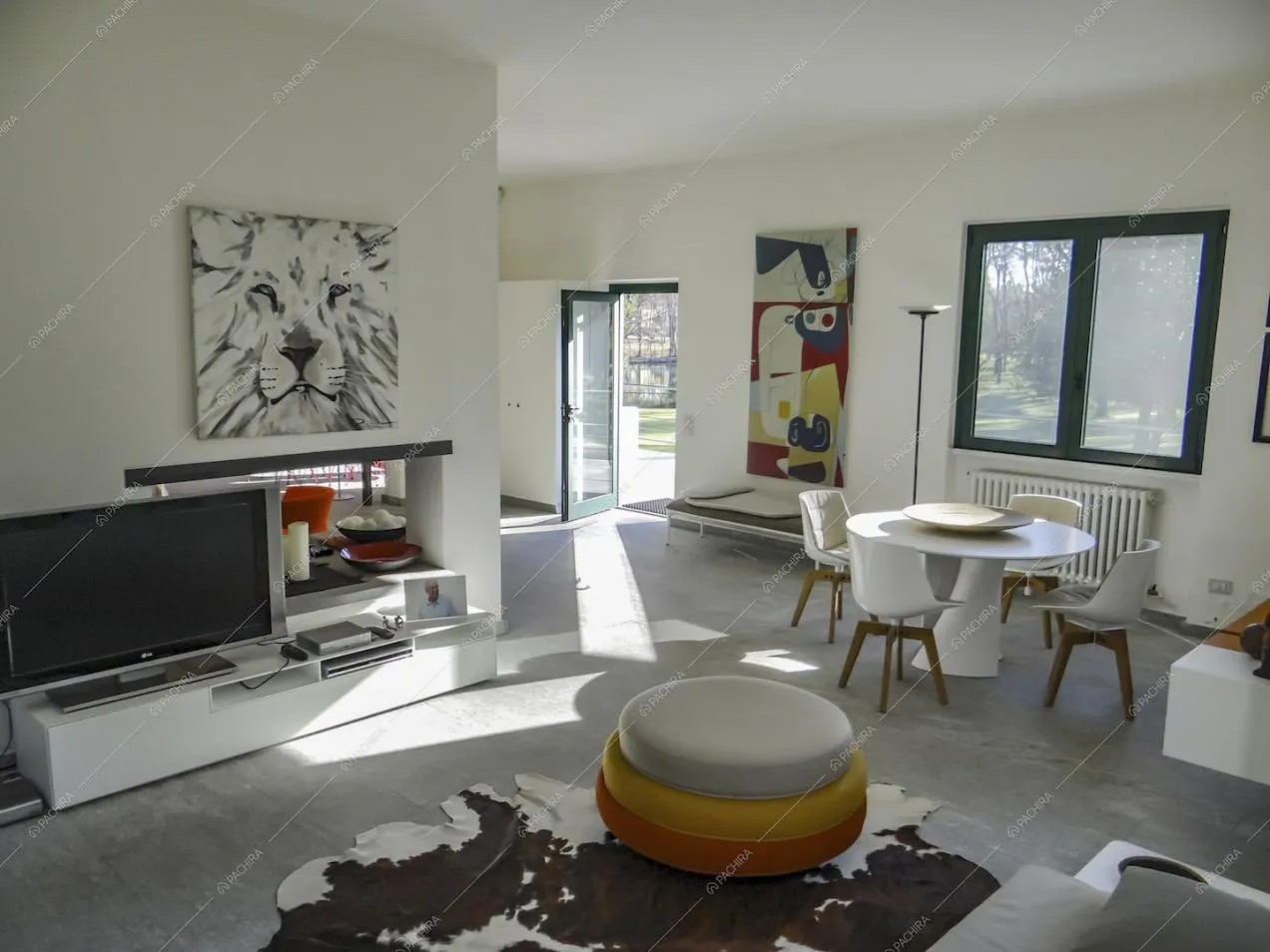 Sala dal pavimento in marmo con pouf di design e tavolo da pranzo bianco