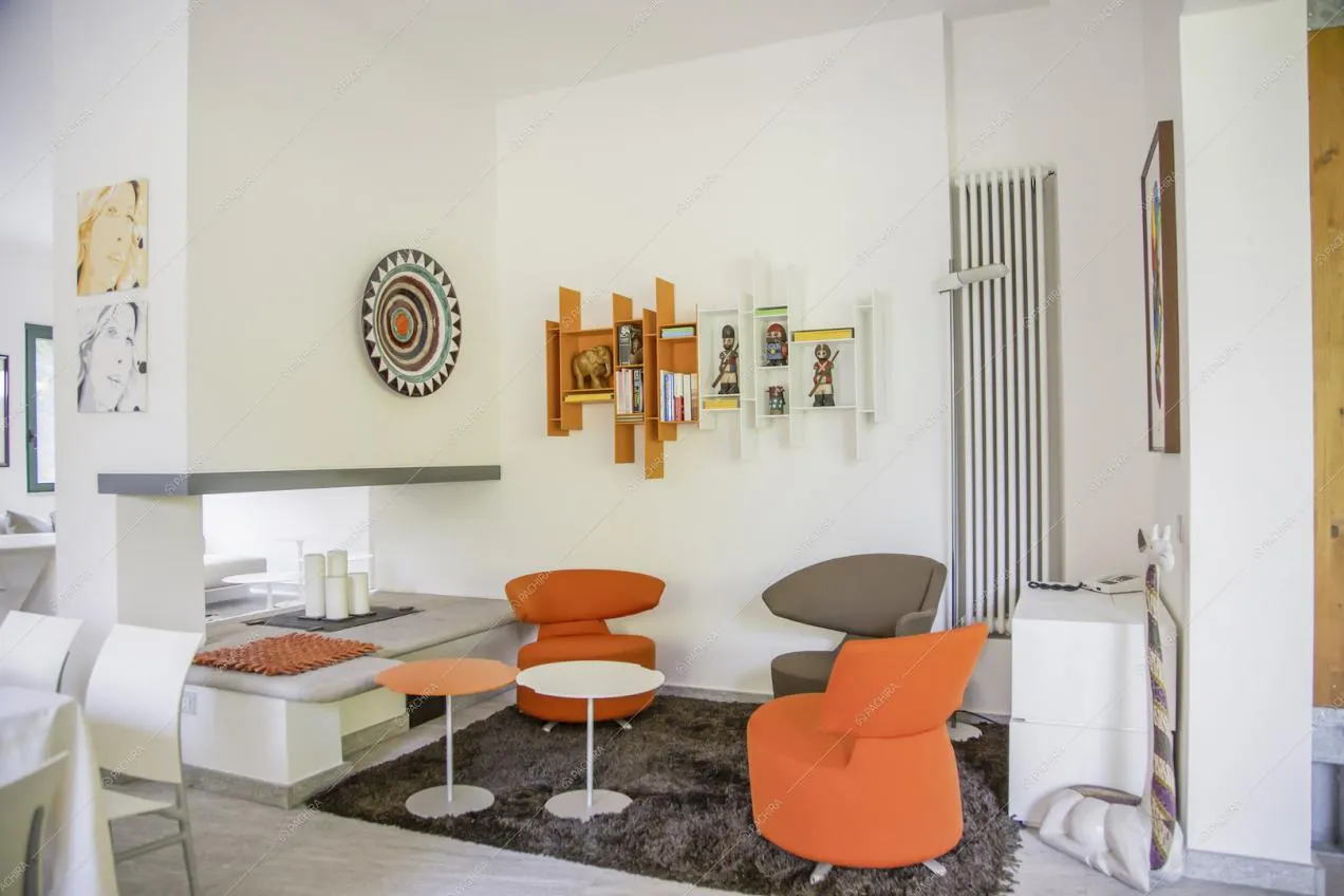 Salotto con poltrone di design, pareti bianche e pavimento in marmo