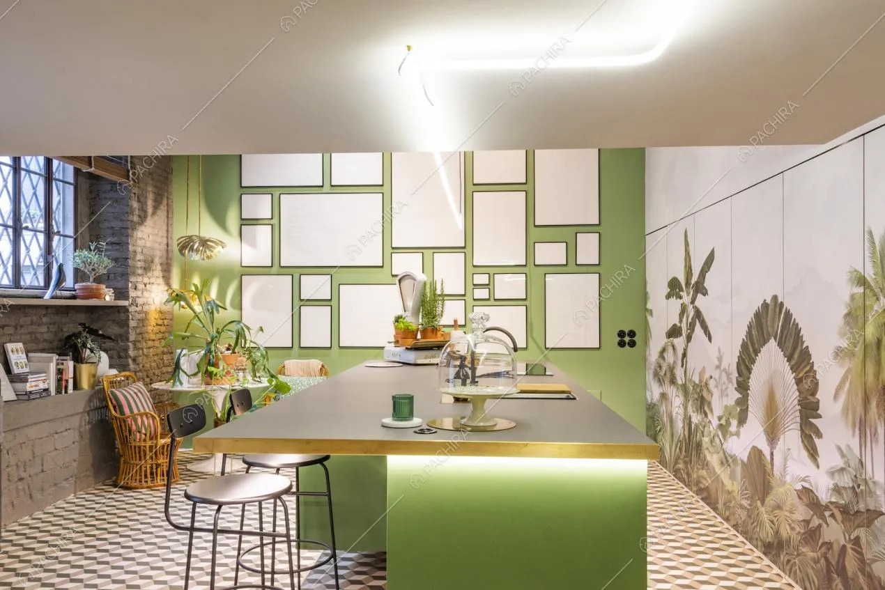 Cucina a isola verde circondata da pareti decorate nei toni del verde