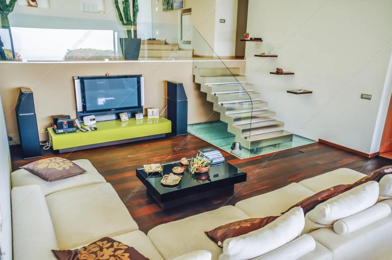 Zona living con divano bianco angolare e televisione