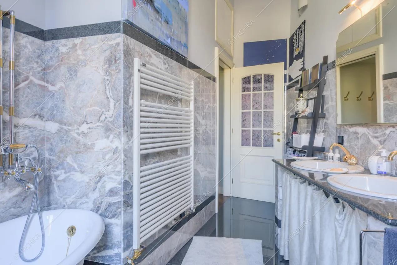 Bagno con pareti rivestite in marmo e lavandini