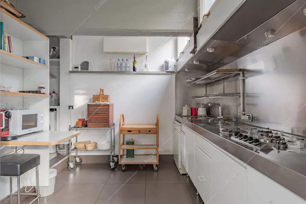 Cucina in acciaio con fornelli a gas della villa China, location in stile contemporaneo a Roma
