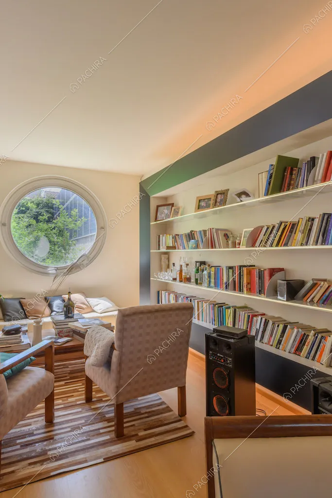 Salotto con divano, poltrone, libreria e pavimento in parquet