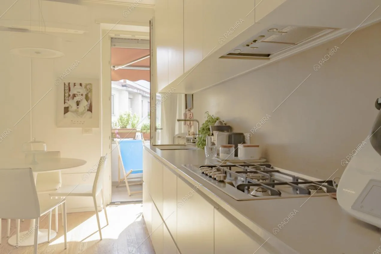 Mobili da cucina bianchi e tavolo tondo con sedie