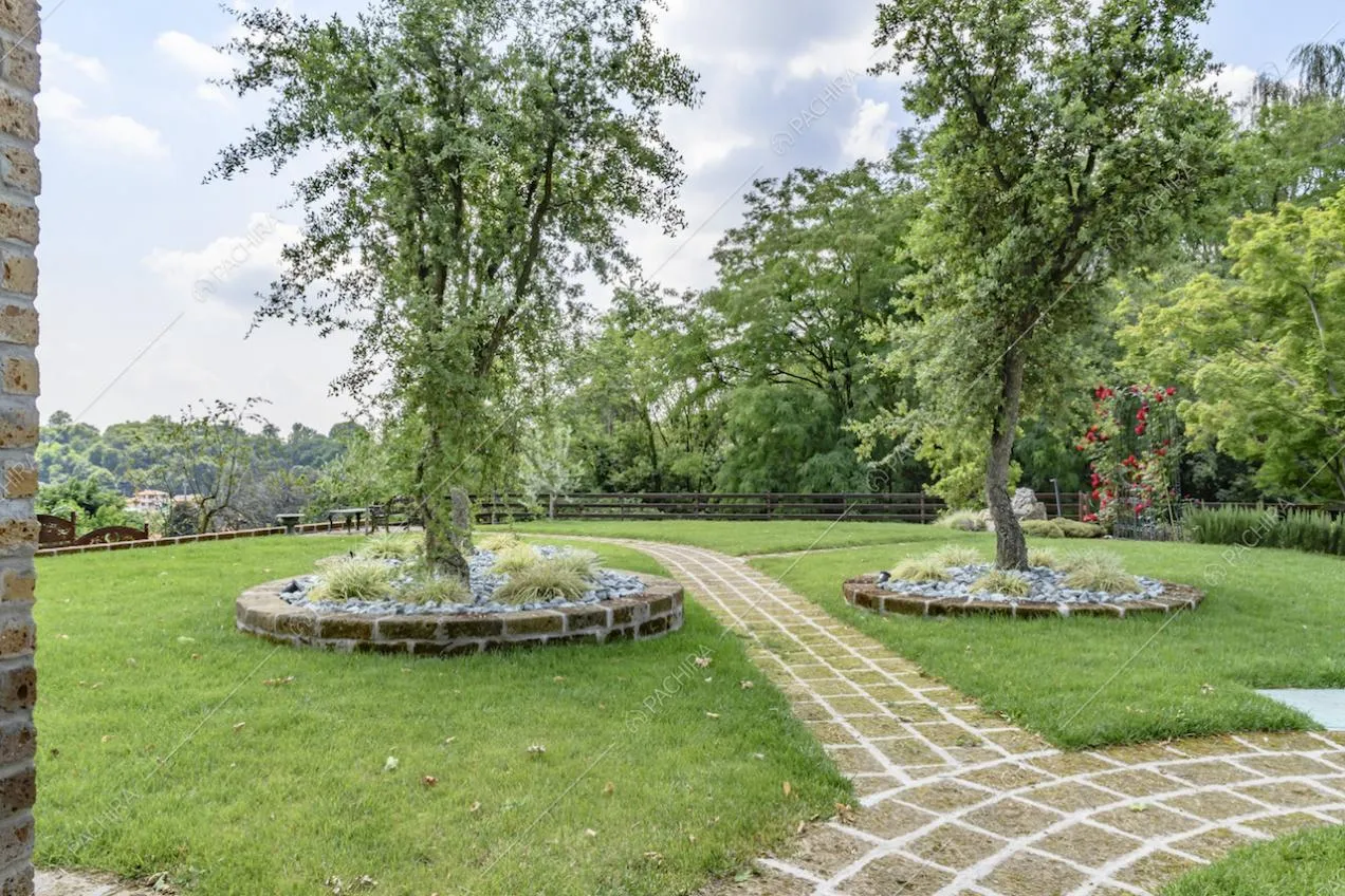Ampio giardino privato con vialetto in pietra e alberi