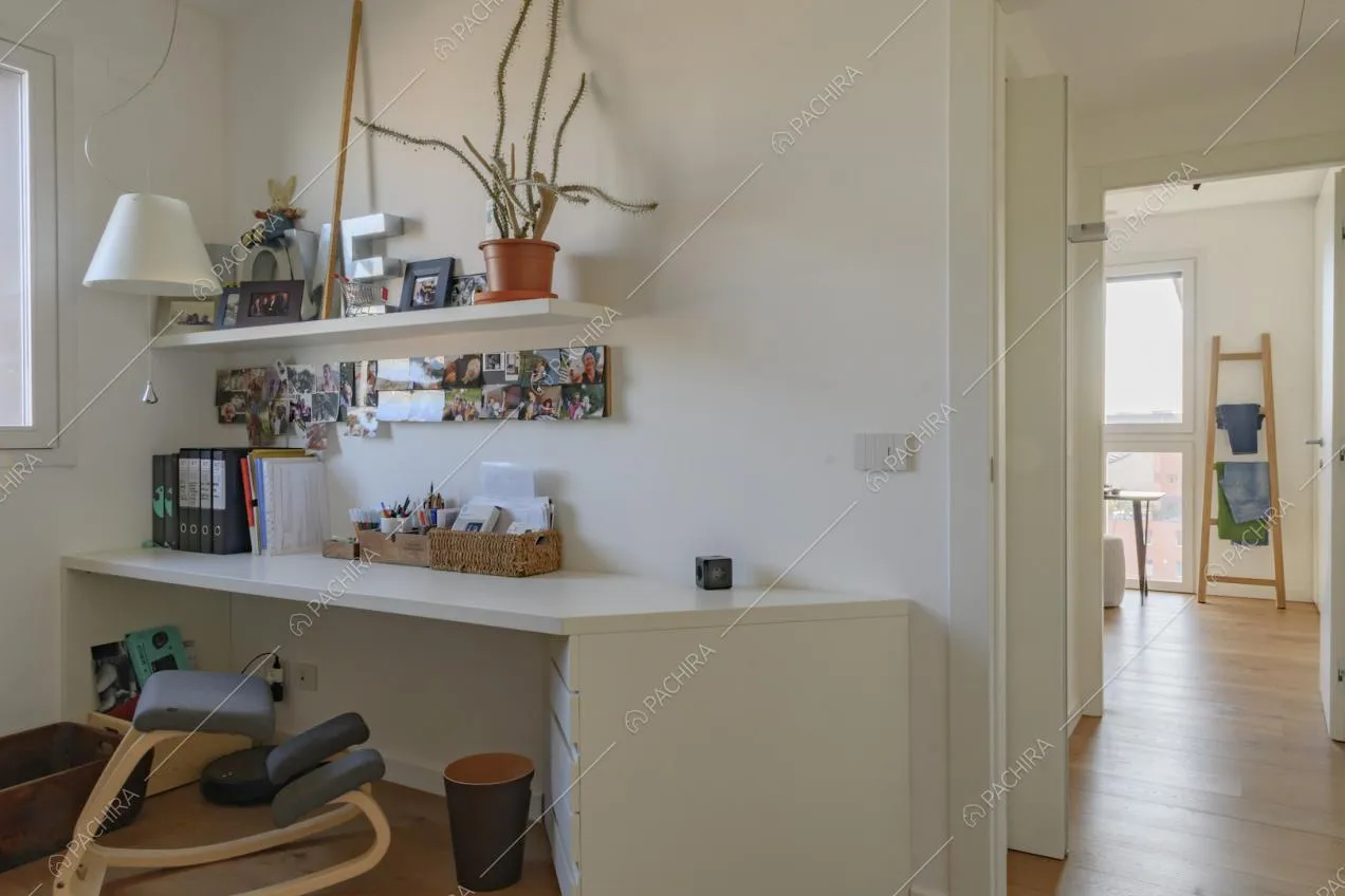Dallo studio con le pareti bianche vista sul corridoio e sulla camera da letto