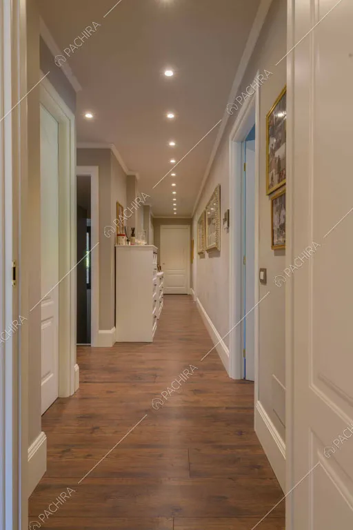 Pareti grigie e pareti bianche con boiserie nel corridoio con pavimento in parquet