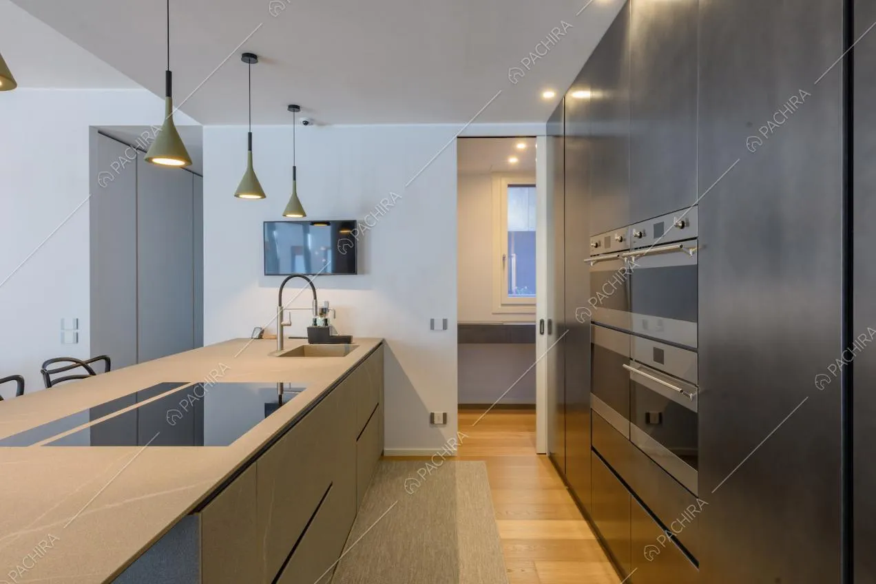 Pavimento in parquet nella cucina con isola grigia con fornelli a induzione