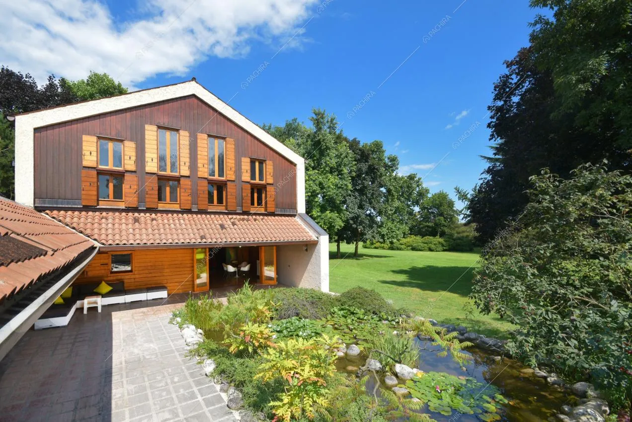 Il grande parco con stagno all'esterno della villa con infissi in legno