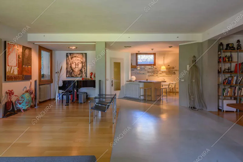 Pavimento in parquet e in cemento lisciato nella zona living con pianoforte