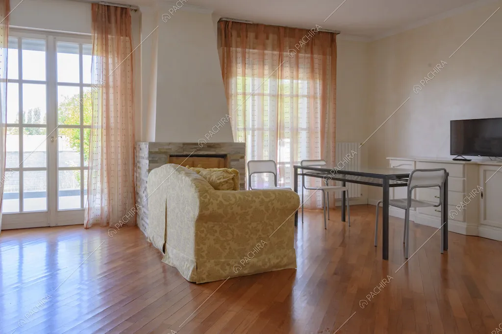 Sofà in stoffa vicino al camino e pavimento in parquet