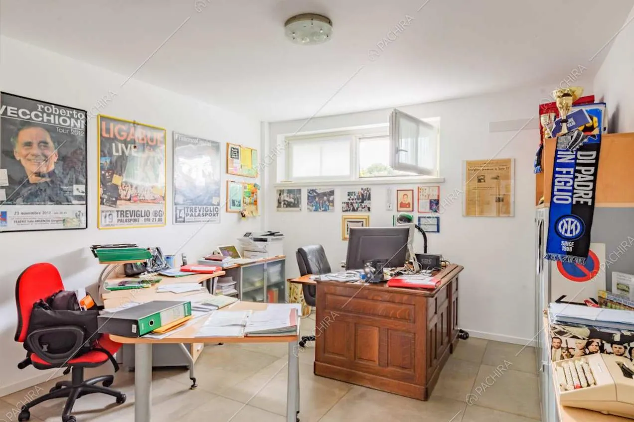 Scrivania in legno con boiserie nello studio con pareti bianche