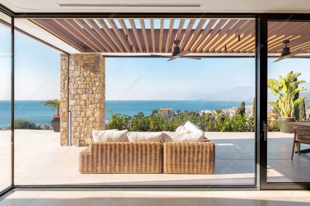 Dalla vetrata della zona living vista sulla veranda con divanetto e sul mare