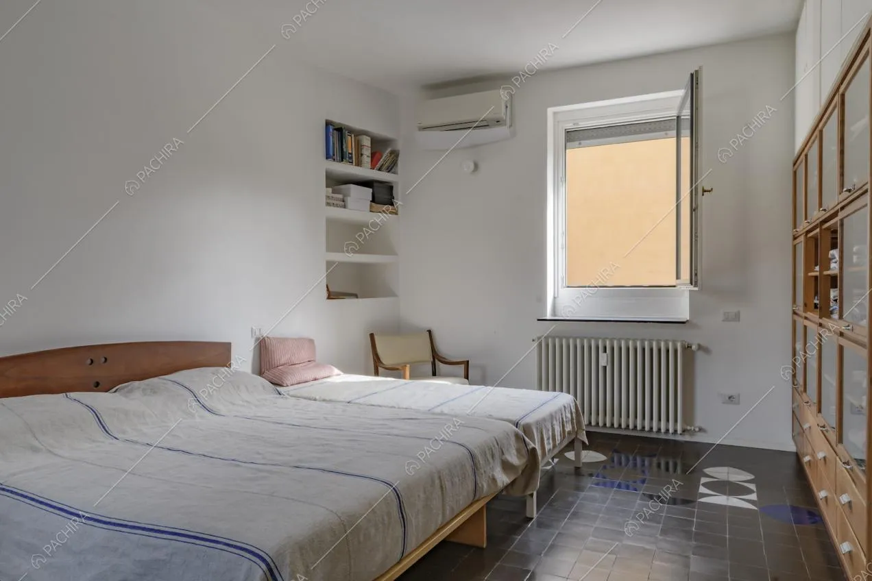 Camera da letto con letto matrimoniale, letto singolo e piastrelle d'epoca anni 70 