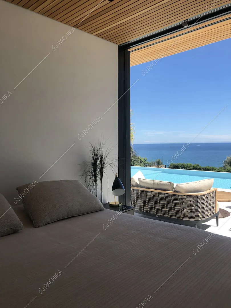Camera da letto matrimoniale con vista sulla terrazza con piscina e sul mare tramite porta-finestra