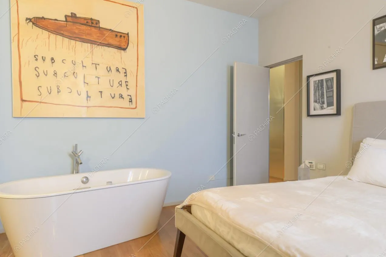 Camera da letto con pareti azzurre e vasca da bagno 