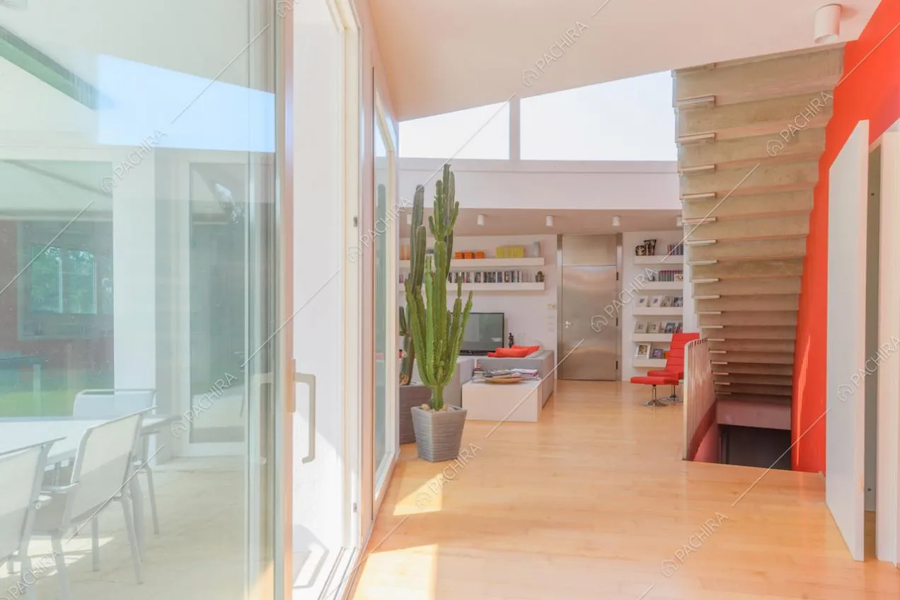 Pavimento in parquet nella zona living con vetrate e scale