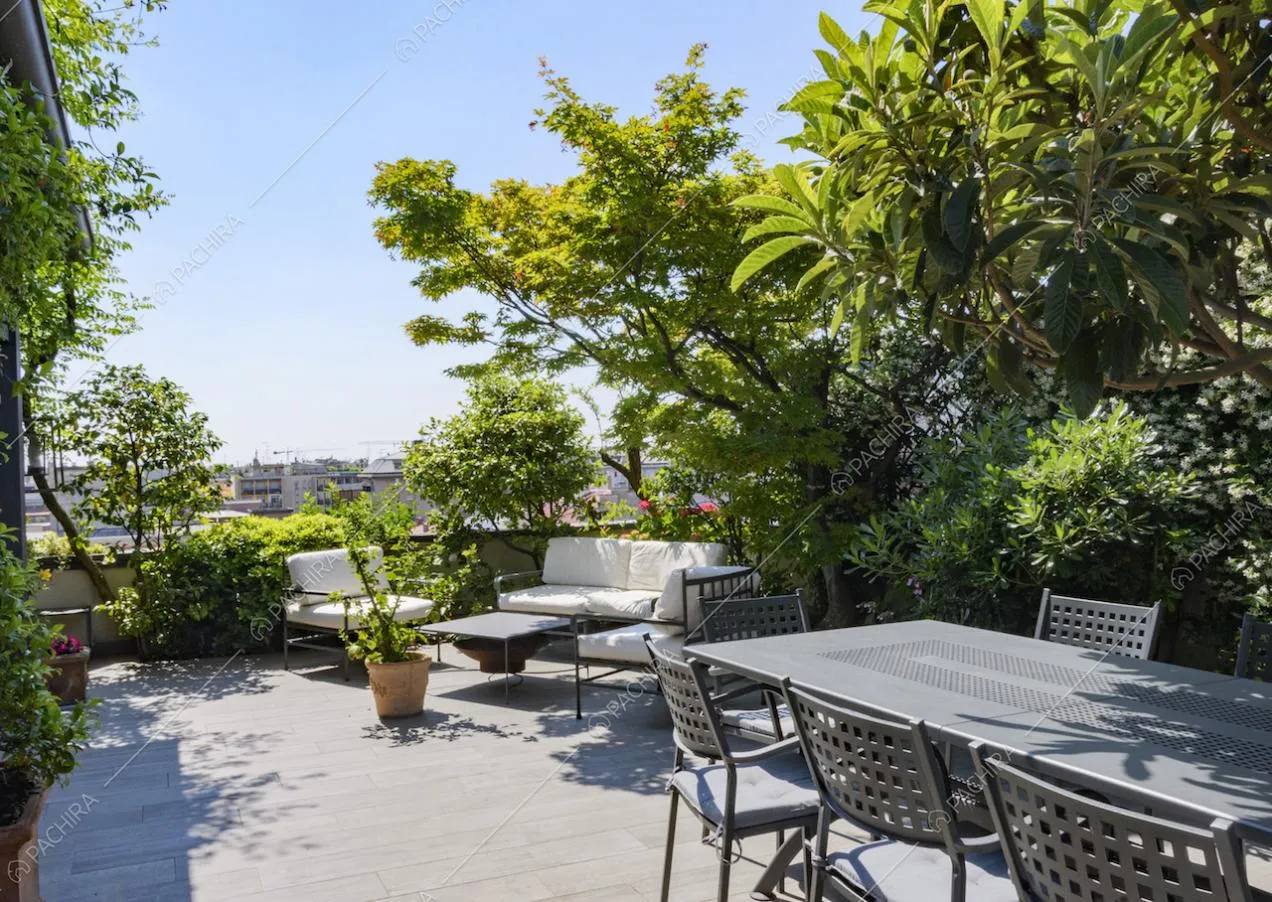 Zona relax sulla terrazza con divanetti e vista sulla città