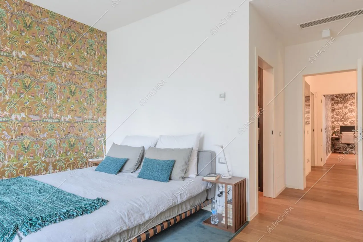 Camera da letto con carta da parati a fantasia tropicale e pavimento in parquet
