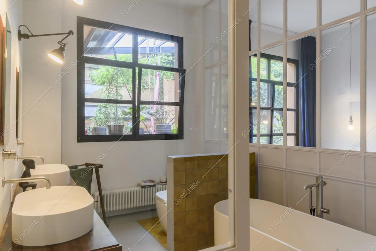 Bagno con doppio lavandino, vasca e vetrate bianche