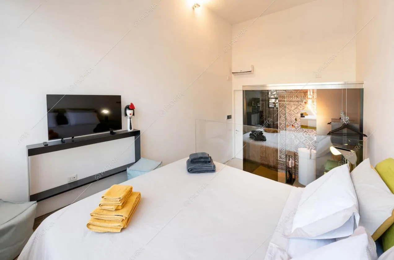 Camera da letto matrimoniale con pareti bianche e bagno privato
