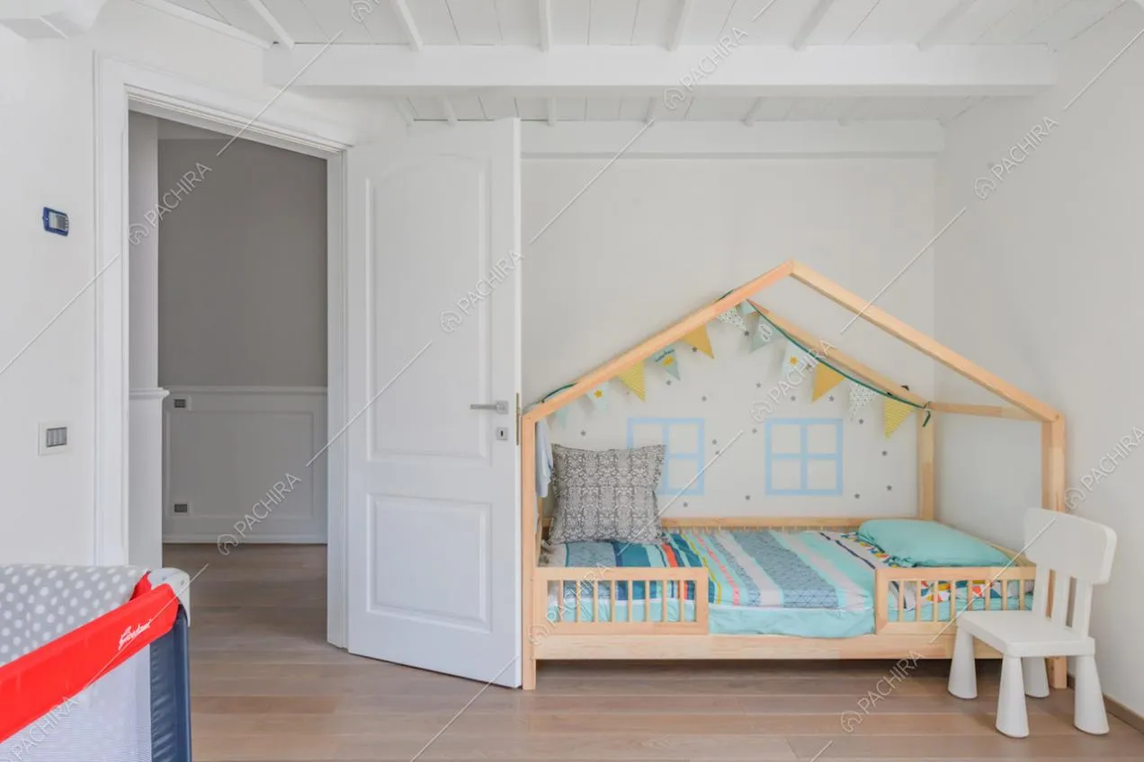Camera da letto dei bambini con pavimento in parquet e pareti bianche