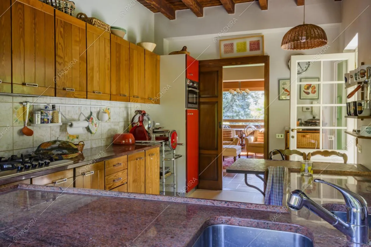 Travi a vista sul soffitto della cucina e affettatrice di design