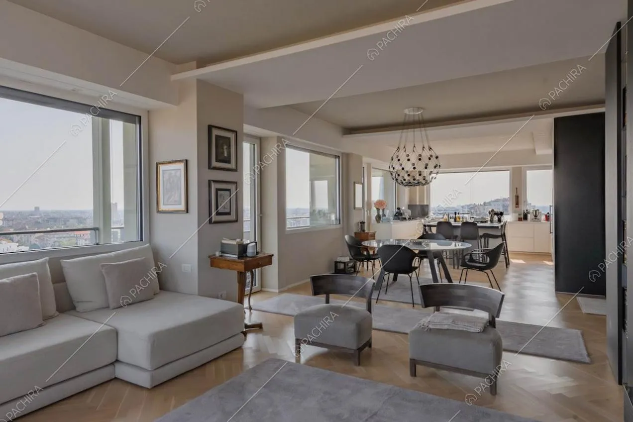 Ampia zona living con pavimento in parquet, divano e cucina a vista con isola