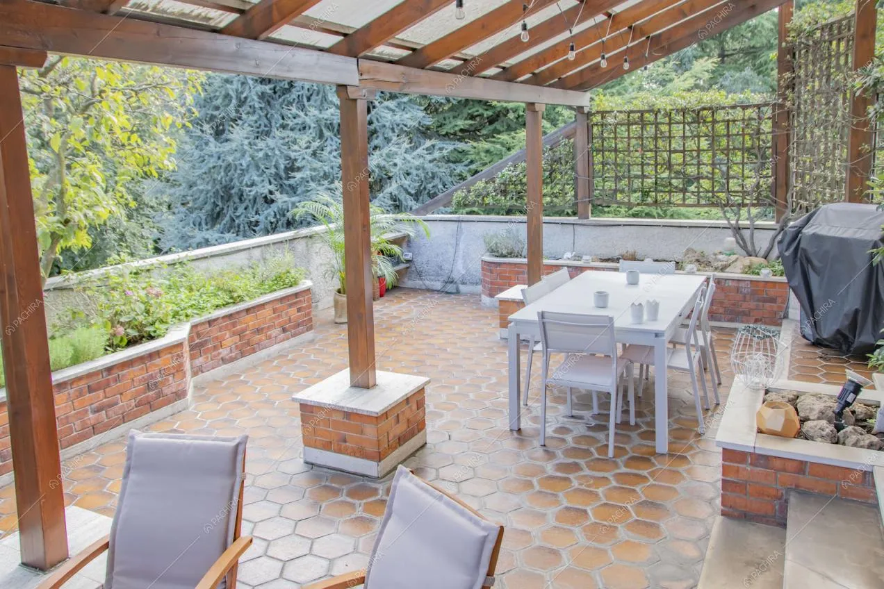 Terrazza con pavimento in cementine e veranda con travi in legno a vista