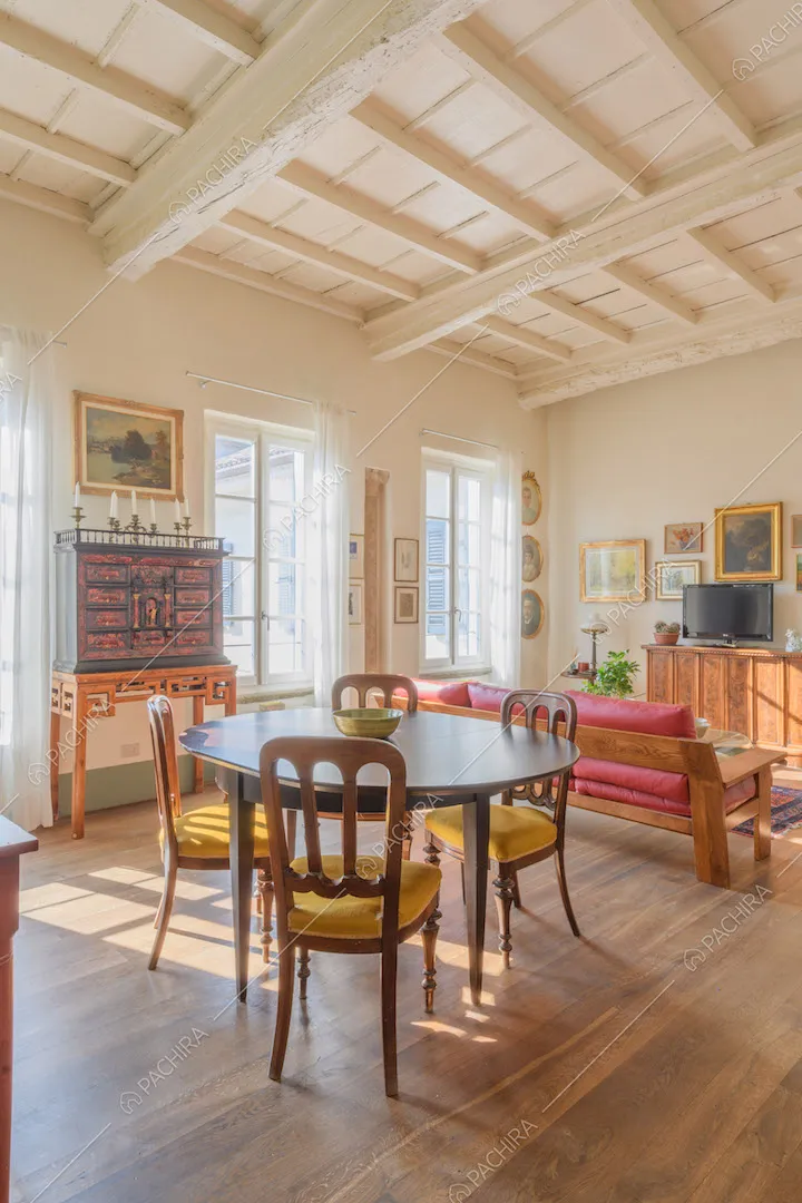 Tavolo da pranzo ovale, pavimento in parquet e soffitto a cassettoni bianco