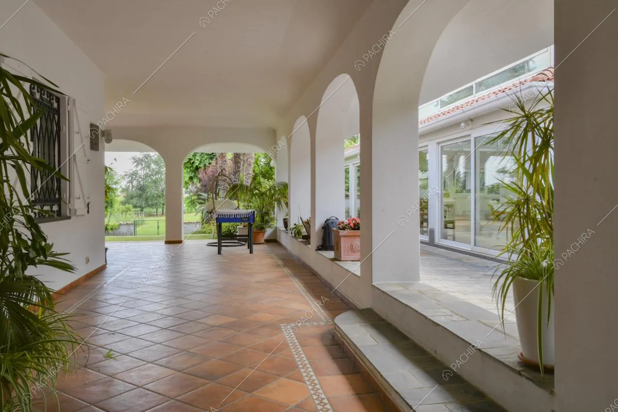 Dalla veranda con archi e pavimento in piastrelle accesso alla serra