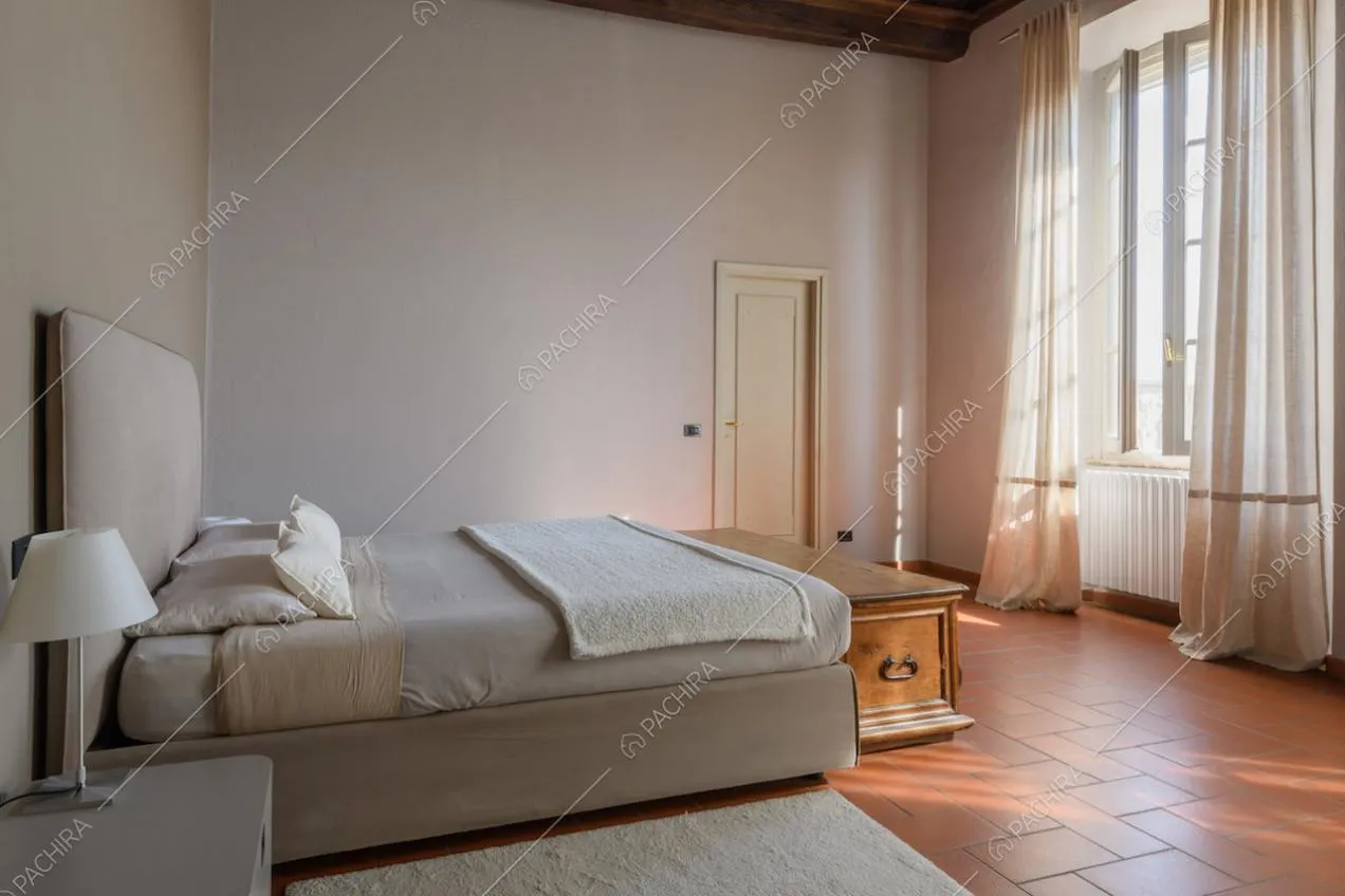 Camera da letto matrimoniale in stile minimal con cassapanca e grandi vetrate
