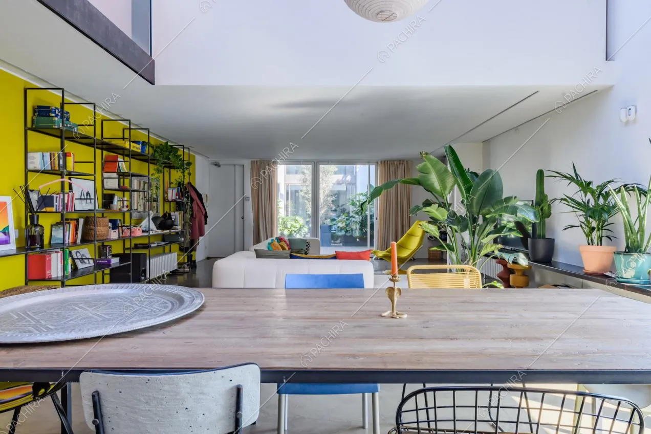 Dal tavolo da pranzo vista sul divano angolare bianco e sulla porta-finestra per accedere alla terrazza