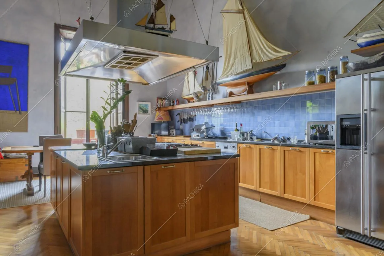 Spaziosa cucina a isola in legno con frigorifero metallizzato