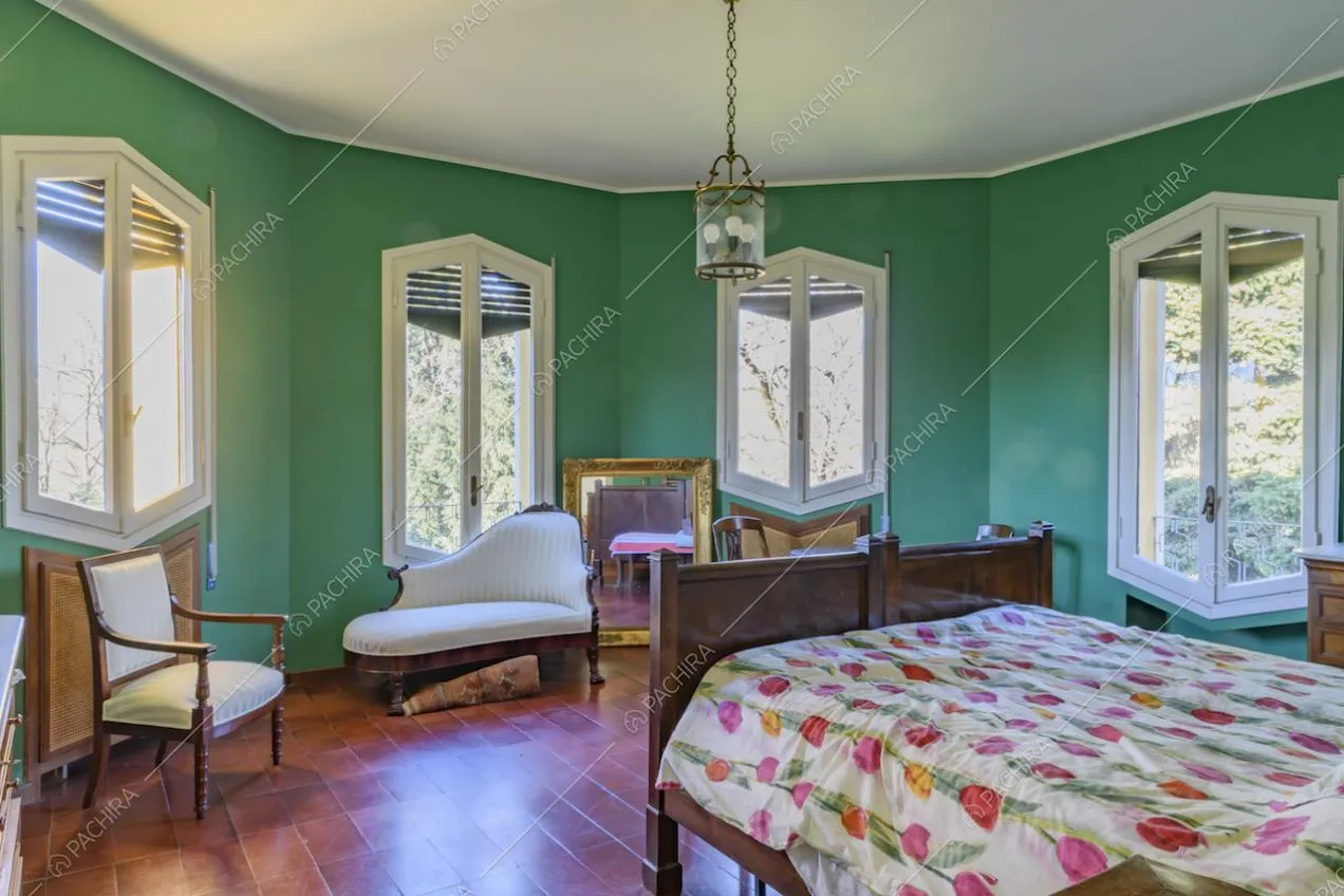 Camera da letto dalle pareti verdi e con pavimento in cotto