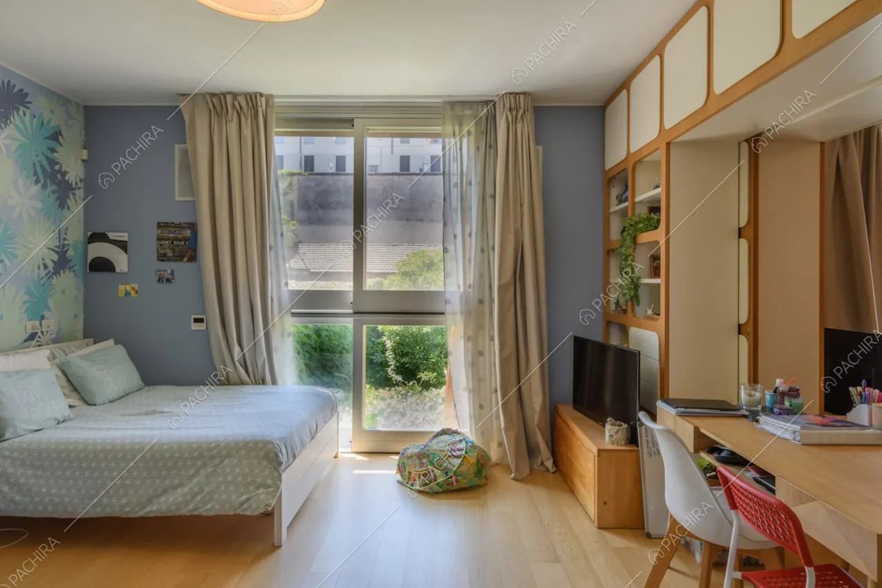 Camera da letto matrimoniale con pavimento in parquet e scrivania
