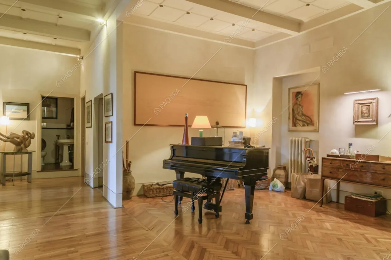 Pianoforte a coda, quadro astratto e mobile antico