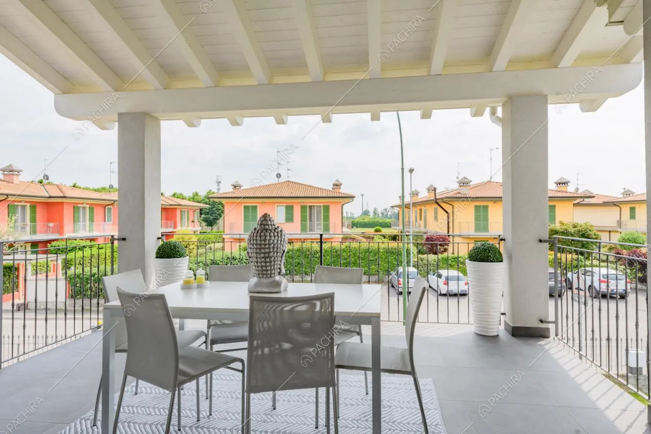Tavolo da pranzo sulla terrazza coperta da un soffitto in travi bianche a vista