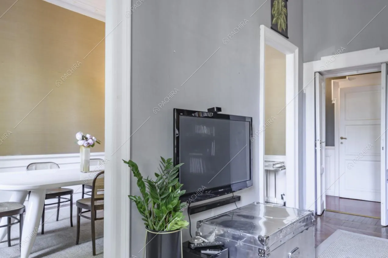 Televisore tra le porte che collegano soggiorno e sala da pranzo