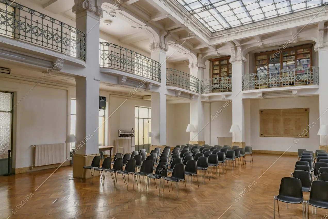 Ampio salone, con colonne bianche, circondato da una balconata con balaustre azzurre